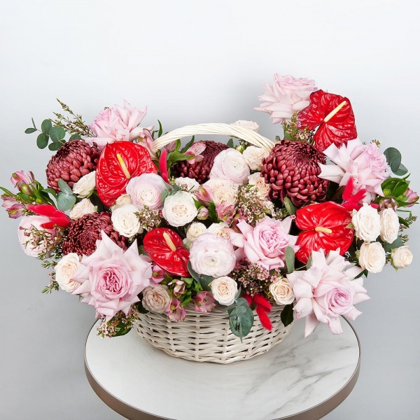 Red cut anthurium - 4, Chrysanthemum Bigoudi purple - 4, Peony style roses - 7, Ranunculus Pink - 5, Alstromeria white, soft pink - 11, Peony sprayrose - 5, Medium Basket, Oasis, Waxflower (1 pc.), Eucalyptus, Dried flowers in assortment