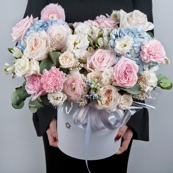 Blue/purple hydrangea - 2, Peony style roses - 3, Ranunculus Pink - 3, lisianthus - 3, Pink carnation - 7, Alstromeria white, soft pink - 11, Peony sprayrose - 2, Peony rose pink 'OHara' - 3, Round flower box medium, Oasis, Ozotamnus, Oksipetalum, Eucalyptus, Ribbon
