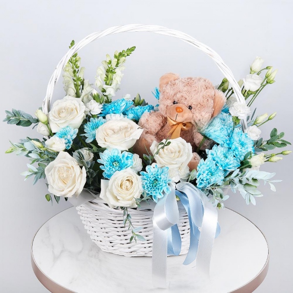 White Matthiola - 2, White rose 50 cm - 9, Chrysanthemum spray Baltica painted blue - 3, White spray carnation - 4, lisianthus - 3, Medium Basket, Oasis, Pistachio, Teddy bear 20 cm, Ribbon