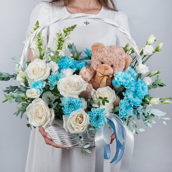 White Matthiola - 2, White rose 50 cm - 9, Chrysanthemum spray Baltica painted blue - 3, White spray carnation - 4, lisianthus - 3, Medium Basket, Oasis, Pistachio, Teddy bear 20 cm, Ribbon