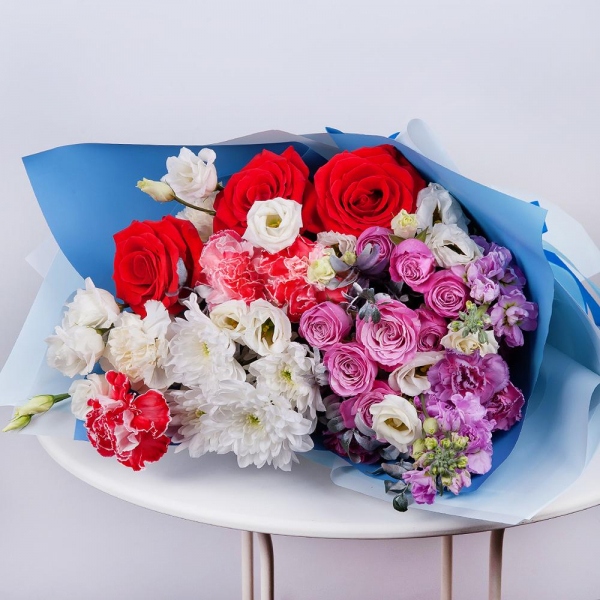 Baltica White Spray Chrysanthemum - 2, Peony sprayrose - 2, Red rose 50 cm - 7, Carnation red - 3, Matthiola Lilac - 2, lisianthus - 3, Carnation spray - 3, Carnation white, cream - 3, Pistachio, Wrapping Paper, Ribbon