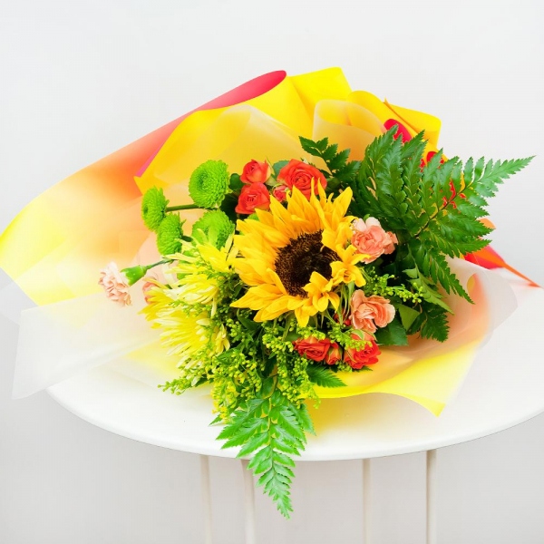 Sunflower - 1, Baltica Yellow Spray Chrysanthemum - 1, Spray rose: yellow, orange 50 cm - 3, Pink spray carnation - 2, Athos pom Feeling Green - 1, Solidago (1 pc.), Fern (1 pc.), Wrapping Paper