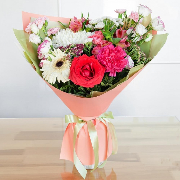 Magnum White Chrysanthemum - 1, Gerbera white - 1, Pink carnation - 2, Santini White Spray Chrysanthemum - 3, Bright pink spray rose mix, 50 cm - 2, Alstromeria white, soft pink - 3, Red rose 50 cm - 2, Pink Lisianthus (Eustoma) - 2, Pink spray carnation - 2, Ozotamnus, White statice, Pistachio, Wrapping Paper