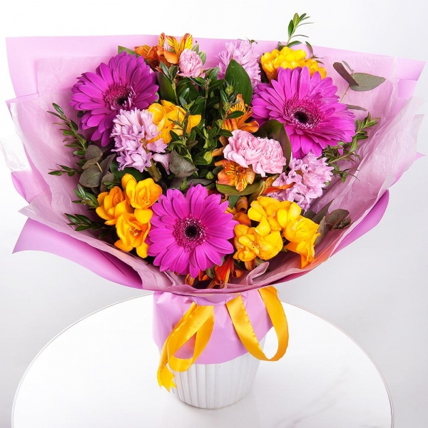 Purple gerbera - 3, Pink Hyacinth - 3, Alstromeria Yellow, Orange - 4, Pink spray carnation - 4, Freesia - 4, Pistachio, Eucalyptus, Wrapping Paper